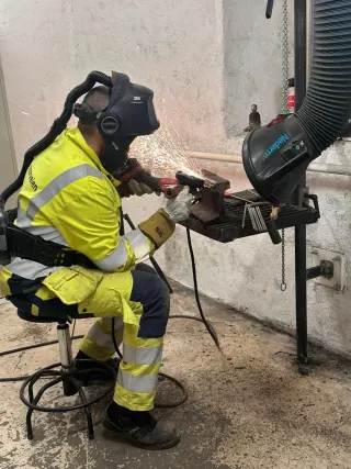 Kursdeltaker sveiser et prøveemne ved benken