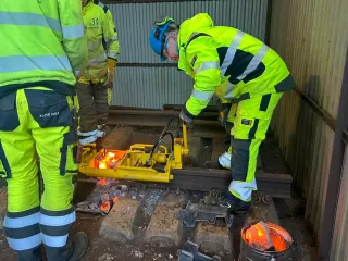 To kursdeltakere klargjør sveiseklipperen på skinnen