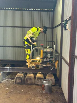 Kursdeltaker bruker profilsliper med skinnen mellom svillene