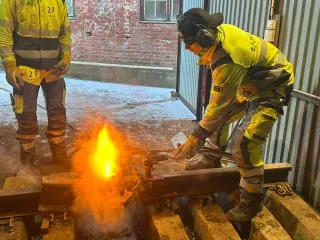 To deltakere ved glødende sveisemateriell i åpningen til sveisesenteret