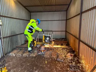 Kursdeltaker bruker profilsliper med gnister langs skinnen