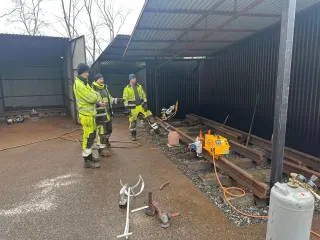 Kursdeltakere ved skinneskjøten og sveisemateriell i en åpen bås
