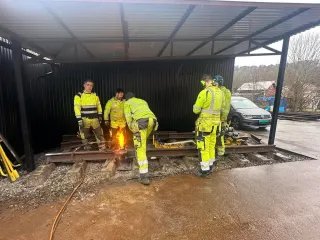 Kursdeltakere følger arbeidet ved en skinneskjøt på uteområdet