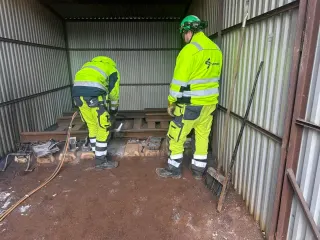 To deltakere forbereder et arbeidsområde ved svillene